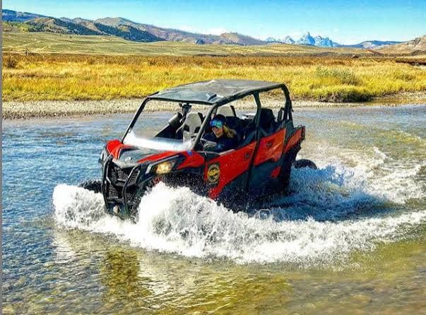 4x4 UTV splashing through a river crossing in Jackson Hole backcountry