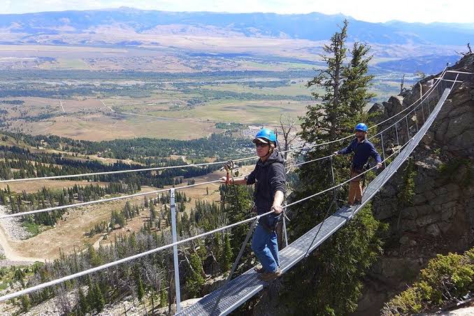 Climbers on a suspension bridge on the Via Ferrata above Jackson Hole valley